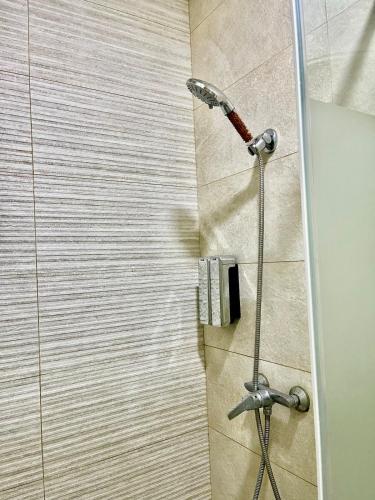 a shower with a shower head in a bathroom at Chic studio with sea view, Wi-Fi & pool in Aïn Harrouda