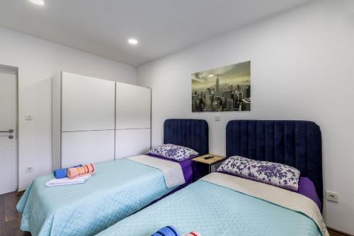 two beds in a room with blue headboards at Villa Little Heaven in Split