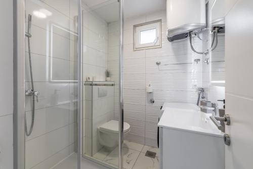 a white bathroom with a toilet and a shower at Villa Little Heaven in Split