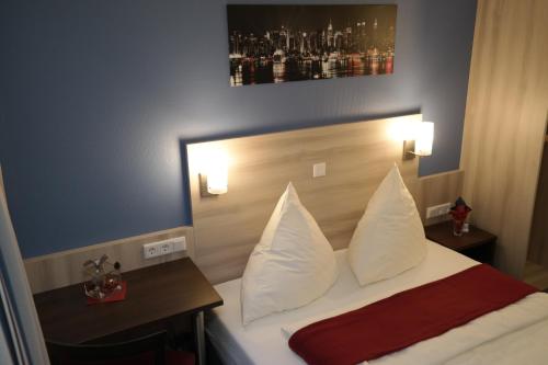 a hotel room with a bed with white pillows at Motel 44 in Geseke