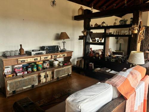 a living room with a couch and wooden shelves at Recanto do Sitio in Tiradentes