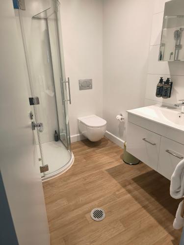 a bathroom with a shower and a toilet and a sink at 204 The Sands in Nelson