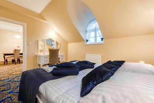 a bedroom with a bed with blue pillows on it at Hotel Dwór Fijewo in Golub-Dobrzyń