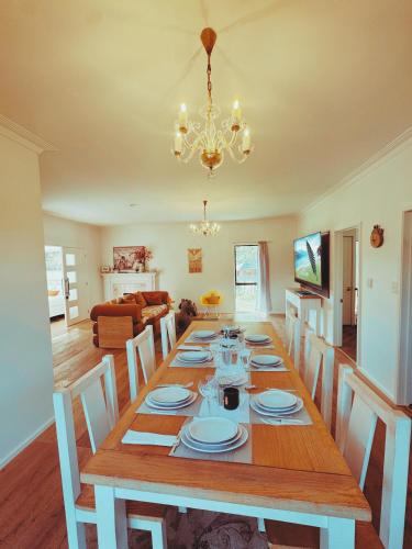 a dining room with a table with chairs and a chandelier at Redwoods Lodge - 6BR & 6BA - Large Groups - Free Parking in Rotorua