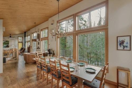 a dining room with a table and some windows at Roaring River Lodge Riverfront Fire pit EV Plug in Rhododendron