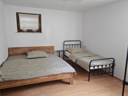 a bedroom with two beds and a mirror on the wall at Unterkunft 24 in Aldingen