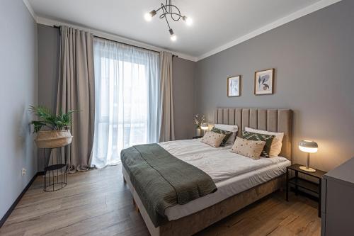a bedroom with a bed and a large window at SECOND HOME Lubawa - 3 pokoje, 5 łóżek, Netflix i Max, parking, winda in Lubawa