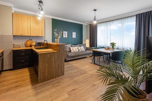a kitchen and living room with a couch and a table at SECOND HOME Lubawa - 3 pokoje, 5 łóżek, Netflix i Max, parking, winda in Lubawa