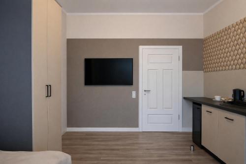 a living room with a television and a kitchen at Modernes Studio im Zentrum mit Parkplatz in Gummersbach