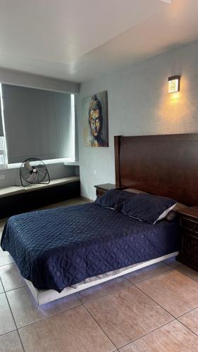 a bedroom with a large bed with a blue comforter at Cuarto a unos pasos de foro sol GNP y AICM in Mexico City