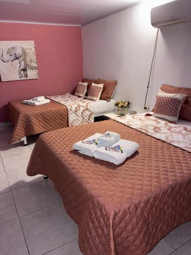 a hotel room with two beds with towels on them at Casa Roma in Rivera