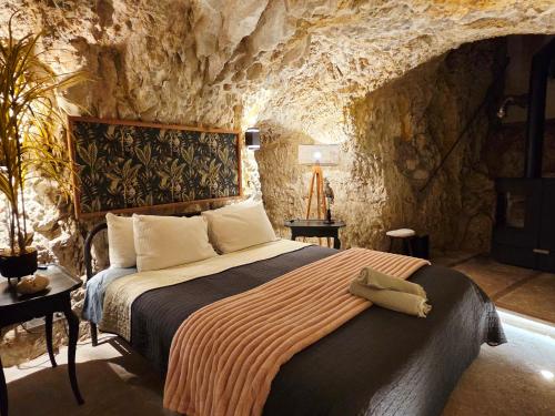 a bedroom with a bed in a stone room at Le Tunnel du Moulin in Noyers-sur-Cher