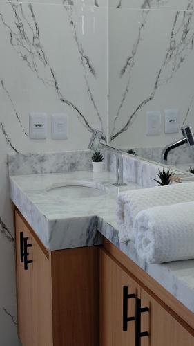 a bathroom counter with a sink and a mirror at Tropical Executive Hotel Flat 205 in Manaus