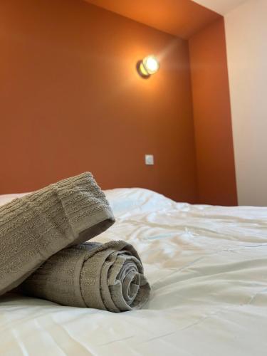 a stack of towels sitting on top of a bed at Charmant appartement moderne A in La Roche-sur-Yon