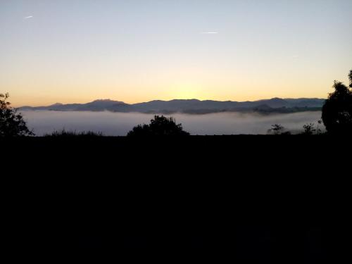 a view of a foggy field with the sunset in the background at Casa Rural Aristondo Agroturismo in Donostia-San Sebastián