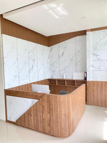 an office lobby with a desk and marble walls at Pavo Guest House in Minangkabau International Airport