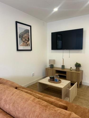a living room with a couch and a flat screen tv at Charmant appartement moderne A in La Roche-sur-Yon