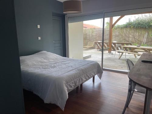 a bedroom with a bed and a sliding glass door at Bidart centre maison vue mer in Bidart