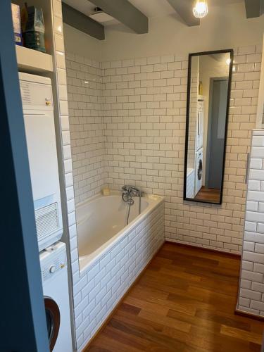 a bathroom with a tub and a sink and a mirror at Bidart centre maison vue mer in Bidart
