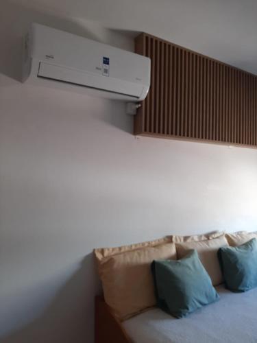 a room with a bed with a air conditioner on the wall at Noche Serena in Puerto Madryn