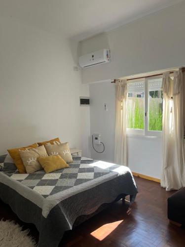 a bedroom with a bed with a checkered blanket at The House in City Bell