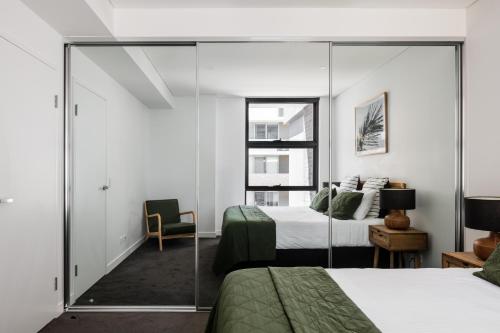 a bedroom with a bed and a mirror at Astra Apartments Wollongong Beatson Street in Wollongong