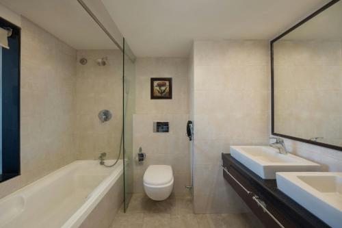 a bathroom with two sinks and a tub and a toilet at The Fern Residency Jodhpur, Series by Marriott in Jodhpur