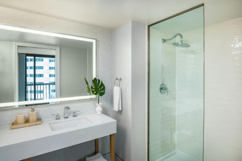 a bathroom with a sink and a glass shower at Ashore Oceanfront Hotel by Marriott in Ocean City