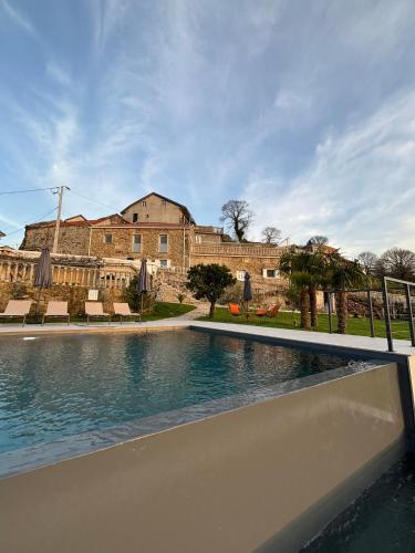 a swimming pool in front of a large building at Casa do Beija in Outeiro