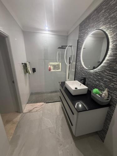 a bathroom with a sink and a mirror at Mullins Bayfield Gardens House in Saint Peter