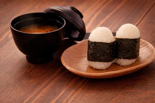 a plate of sushi and a cup of soup at ホテル アイアンプレミアム 西宮北店 男塾ホテルグループ in Nishinomiya