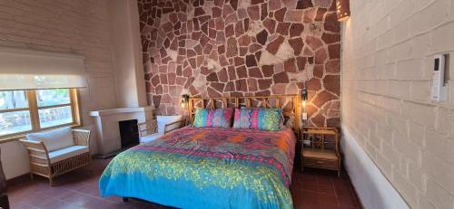 a bedroom with a bed and a stone wall at Sandy Shores Cabaña 10A in La Paz