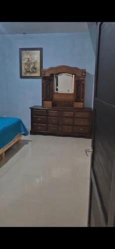 a bedroom with a bed and a dresser with a mirror at Suites Destination in Cuatrociénegas de Carranza