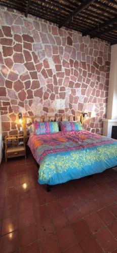 a bed in a room with a stone wall at Sandy Shores Cabaña 10B in La Paz