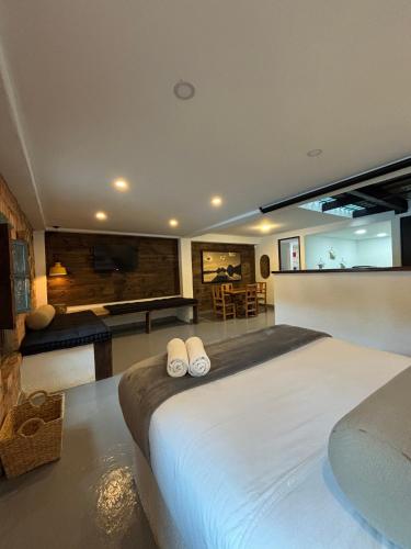 a bedroom with a large bed with two white towels at Kaza Living Usaquén in Bogotá