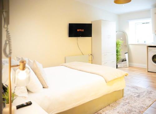 a bedroom with a bed and a tv on the wall at City-Centre Gem Modern Top-Floor Retreat in Cambridge