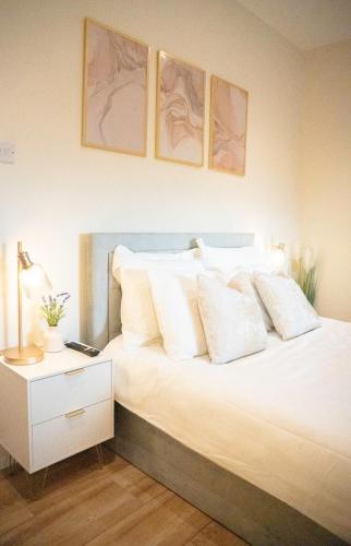 a bedroom with a bed with white pillows at City-Centre Gem Modern Top-Floor Retreat in Cambridge