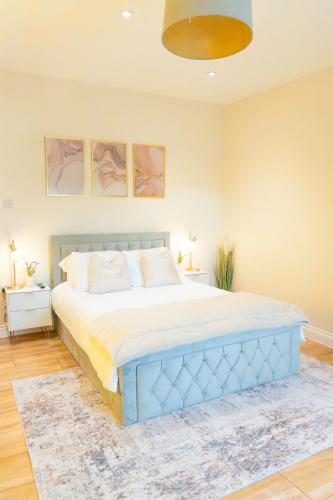 a bedroom with a large bed with a blue headboard at City-Centre Gem Modern Top-Floor Retreat in Cambridge