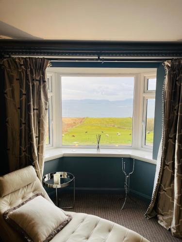 a room with a large window with a couch and a table at The Blue Haven Kilcar in Donegal