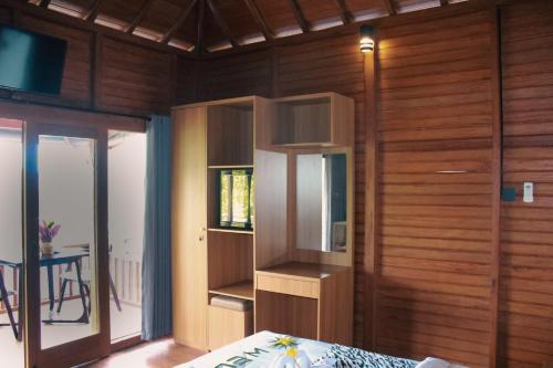 a bedroom with wooden walls and a room with a bed at STHANATAPA HILL's in Sidemen