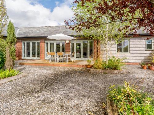 a home with a patio and an umbrella at Marigold in Shepton Mallet
