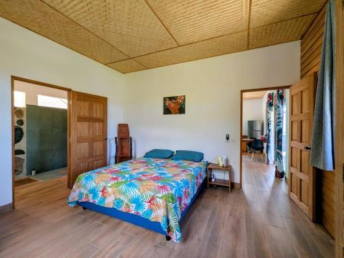 a bedroom with a bed with a colorful bedspread at ManaHenua Lodge in Nuku Hiva