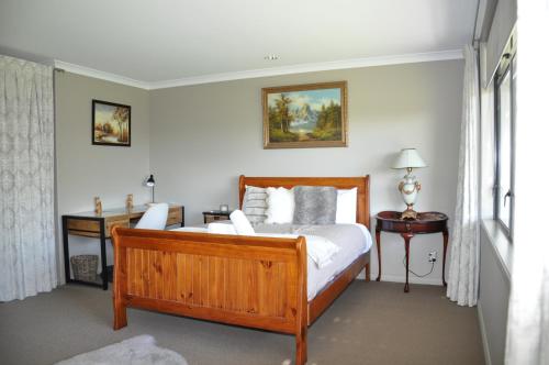 a bedroom with a wooden bed and a window at Parnwell Villa Apartment - The Tropical Oasis in Tauranga