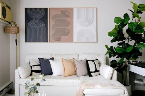 a living room with a white couch with pillows at Modern 1BR w/ Workspace near O'Hare in Chicago