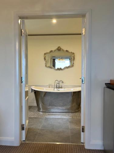 a large tub in a bathroom with a mirror at The Blue Haven Kilcar in Donegal