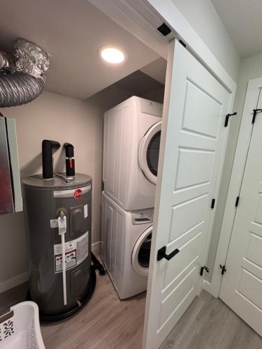 a laundry room with a washing machine and a washer and dryer at Alake Villa in Saskatoon