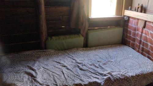 a bed sitting in a room with a window at Mantiqueira lar doce lar in Gonçalves