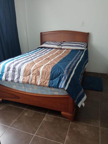a bed with a wooden frame in a bedroom at SUITE CUMBAYA Junto Reservorio in Quito