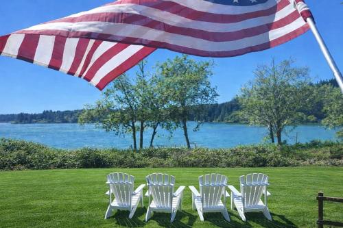 four chairs under an american flag on a lawn with a flag at Siltcoos Station in Siltcoos