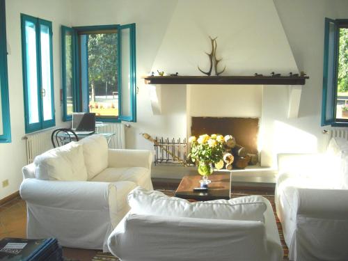 a living room with white furniture and a fireplace at Hotel Rurale Canneviè in Lido di Volano